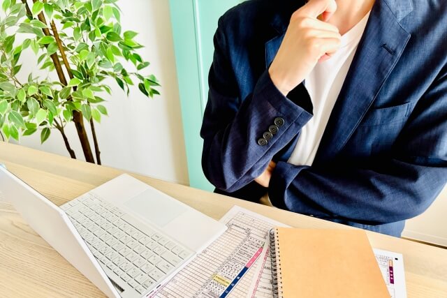 考え込むスーツ姿のビジネスパーソン