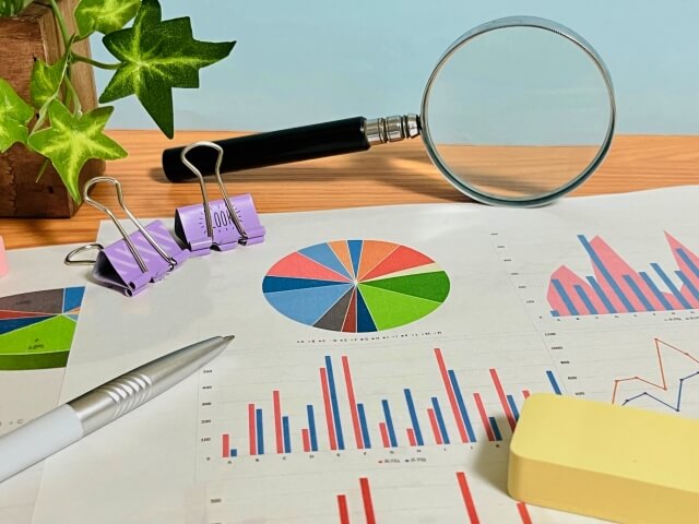 机上の拡大鏡と折れ線グラフ