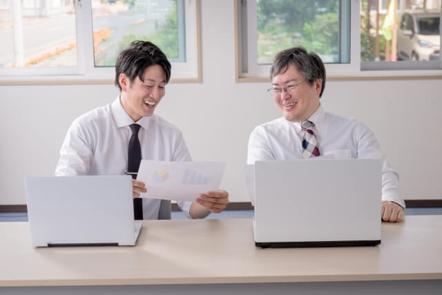 ノートパソコンで打ち合わせする男性たち